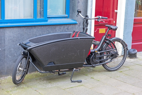 Adobe Stock photo of black electric cargo bike parked outside a building