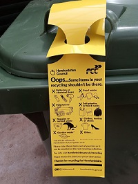 Recycling contamination yellow tag on recycling bin