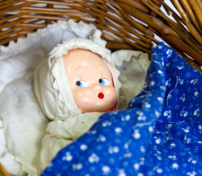Image of doll in cot basket