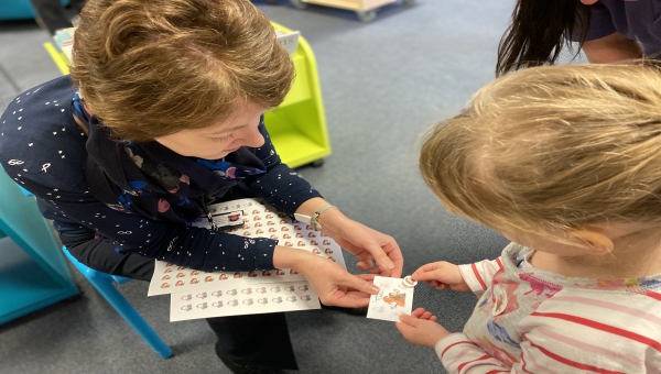 A child chooses a Squirrel Club sticker for her collector card