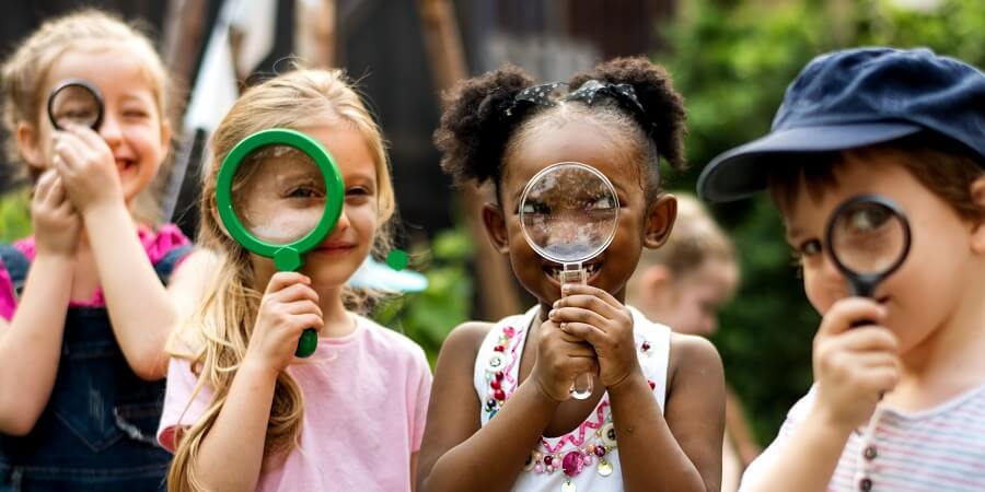 Four children looking through magnifying glasses