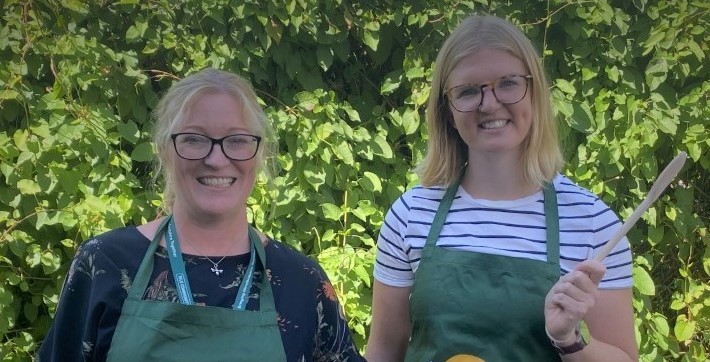Council staff members wear aprons, with one holding a wooden spoon, the other a bowl of fruit, in preparation for the River Festival in Hereford, Saturday 27 August