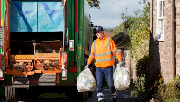 Bin man collecting recycling to place in bin lorry