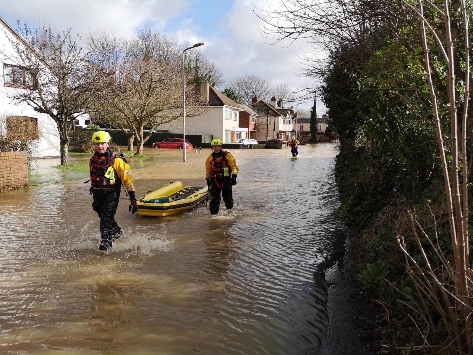 Emergency services pull dinghy through flood water