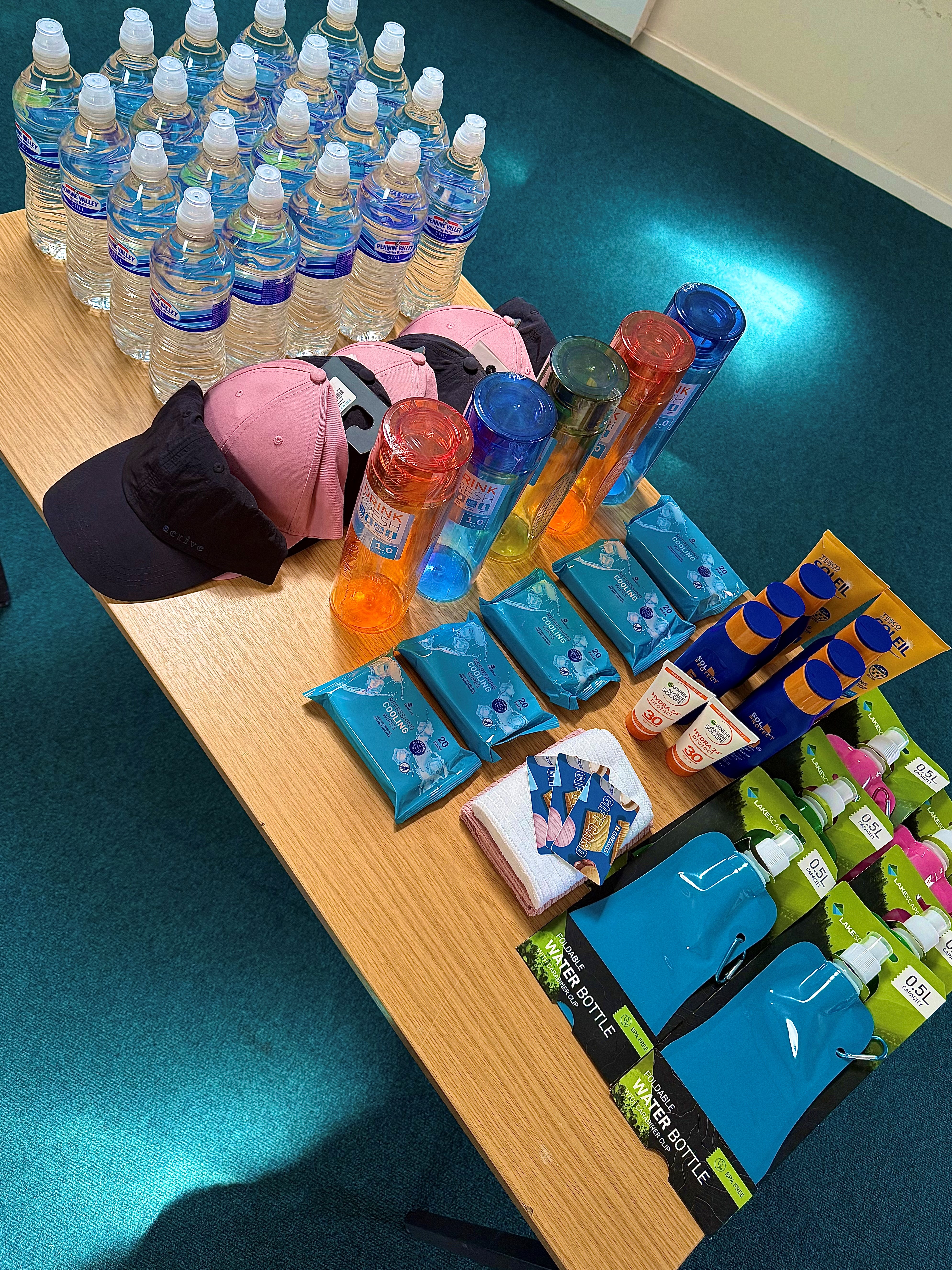 Hot weather pack containing bottled water, sun cream &amp; caps