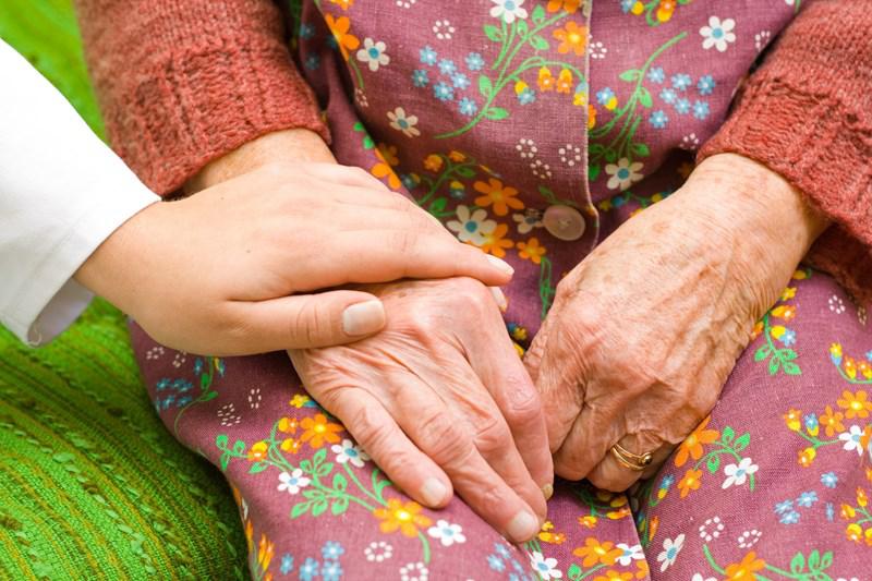 Older person holding hands