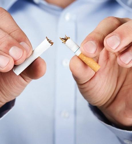 A person snapping an unsmoked cigarette in two
