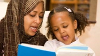Mother and child sharing a dual language reading book
