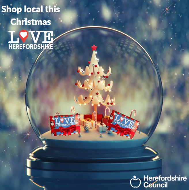 Snowglobe with a christmas tree inside with presents with love local Herefordshire wrapping paper on