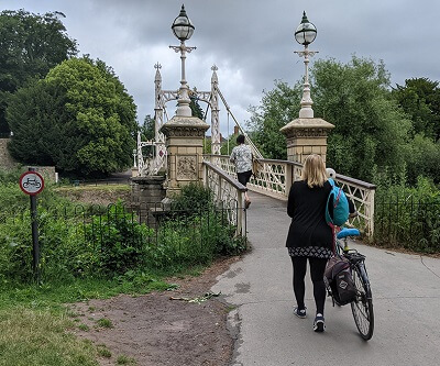 Woman pushing bike at the Victoria Footbridge in Hereford