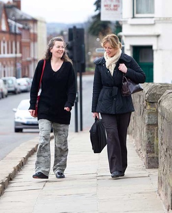 Two women walking to work through a town